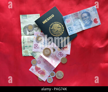 Mexikanischen Pass mit mexikanischen Währung (Banknoten und Münzen) auf einem roten Hintergrund. Stockfoto