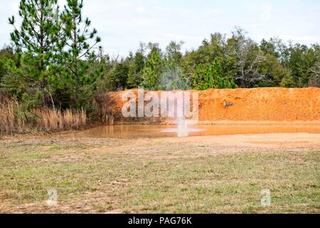 Wasser spritzt in großen roten Lehm Pfütze Stockfoto