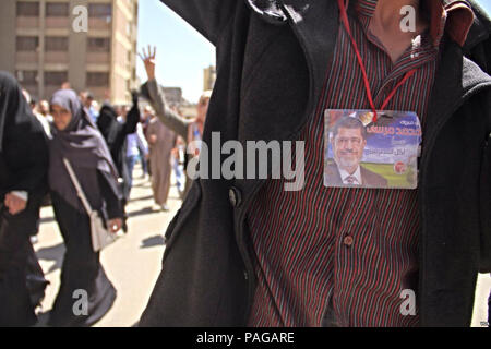 Eine Demonstrantin trägt ein Bild des gestürzten Präsidenten Mohamed Morsi während einer Demonstration in Kairo - 28-Mär-2014.. Stockfoto