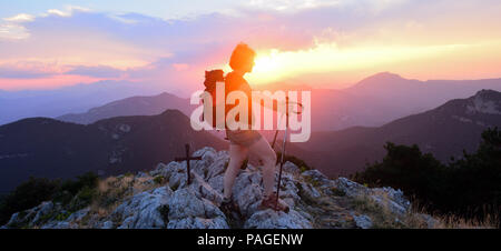 Weibliche Wanderer, der den Sonnenuntergang von der Spitze Stockfoto