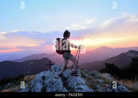 Weibliche Wanderer, der den Sonnenuntergang von der Spitze Stockfoto
