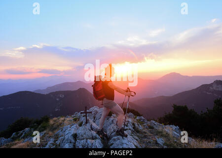 Weibliche Wanderer, der den Sonnenuntergang von der Spitze Stockfoto