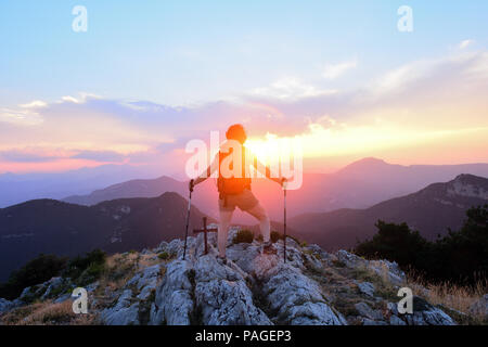 Weibliche Wanderer, der den Sonnenuntergang von der Spitze Stockfoto