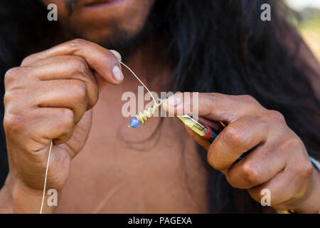 Schmuckhersteller Hände erstellen Ohrringe aus Messing Metall string Stockfoto