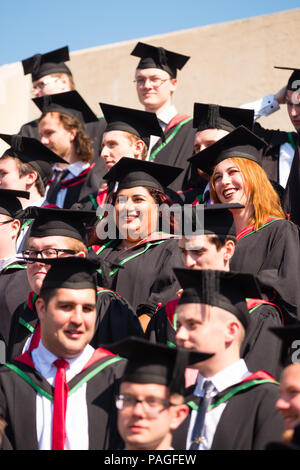 Hochschulbildung im Vereinigten Königreich: Absolventen von Aberystwyth University, in ihren traditionellen Mörser Boards und Schwarz akademische Kleider, für ihre traditionelle Gruppenfoto posiert. Juli 2018 Stockfoto