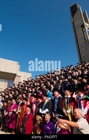 Hochschulbildung im Vereinigten Königreich: Absolventen von Aberystwyth University, in ihren traditionellen Mörser Boards und Schwarz akademische Kleider, für ihre traditionelle Gruppenfoto posiert. Juli 2018 Stockfoto