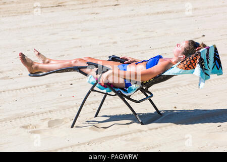 Bournemouth, Dorset, Großbritannien. 23. Juli 2018. UK Wetter: Die hitzewelle weiter, da die Temperaturen auf einem glühend heiße und sonnige Tag in Bournemouth Strände mit blauer Himmel und Sonnenschein ungebrochen steigen. Sunseekers Kopf ans Meer, um Sonne zu tanken. Frau, Sonnenbaden am Strand. Credit: Carolyn Jenkins/Alamy leben Nachrichten Stockfoto