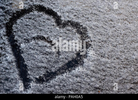 Eine Zeichnung in der Form eines Herzens auf den gefallenen Schnee auf dem Auto Glas Stockfoto