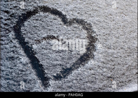 Eine Zeichnung in der Form eines Herzens auf den gefallenen Schnee auf dem Auto Glas Stockfoto