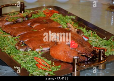 Gegrillte Spanferkel servieren auf dem goldenen Teller. Stockfoto