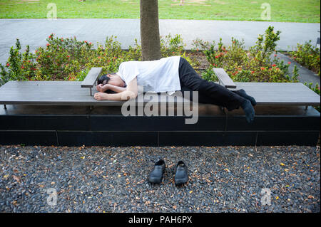 24.05.2018, Singapur, Republik Singapur, Asien - eine Frau gesehen wird, zu einem kurzen Nickerchen auf einer Bank in der Marina Bay. Stockfoto