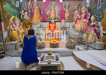 Vor Dienstleistungen eine nicht identifizierte Frau meditiert und betet an der Mailänder Mandir Hindu Tempel in South Ozone Park, Queens, New York. Stockfoto