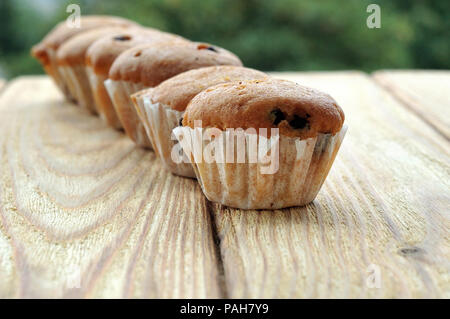 Muffins in einer Reihe auf einem Holz- Hintergrund Stockfoto