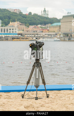 Fernsehen Kamera auf dem Fluss Strand. Lonely Camcorder auf einem Stativ. Vertikale Foto. Stockfoto