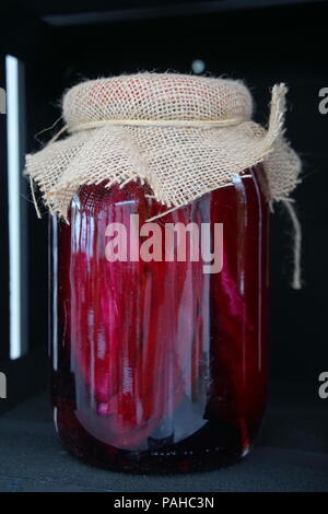 Rote Rüben mit Gewürze im Glas. Glas Glas mit Rüben auf schwarz Holzregal Stockfoto