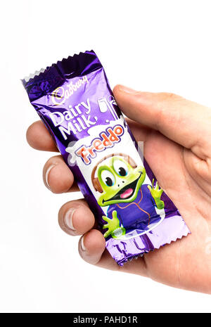 Ein Junge mit einem Cadbury Freddo Schokolade vor einem weißen Hintergrund Stockfoto