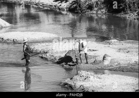 ANTANANARIVO, Madagaskar - 29. JUNI 2011: Unbekannter Madagaskar Frauen füllen die Säcke mit Sand. Menschen in Madagaskar Leiden der Armut aufgrund der Slo Stockfoto