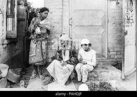 ANTANANARIVO, Madagaskar - 30. JUNI 2011: Unbekannter Madagaskar Frauen mit Kindern sitzen auf der Veranda. Menschen in Madagaskar Leiden der Armut aufgrund Stockfoto