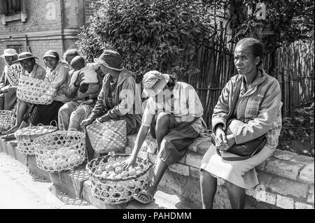 ANTANANARIVO, Madagaskar - 30. JUNI 2011: Unbekannter Madagaskar Frauen verkaufen Äpfel und andere Früchte auf dem Markt. Menschen in Madagaskar Leiden von pov Stockfoto