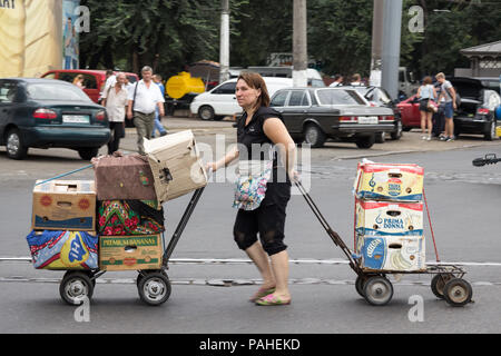 CHISINAU, REPUBLIK MOLDAU - 13. AUGUST 2015: Im Mittleren Alter kaukasische Frau, Bemühungen Ziehen einer Karre im privoz Central Market von Odessa Bild von Th Stockfoto