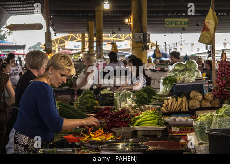 ODESSA, UKRAINE - 13. AUGUST 2015: Alte Frau Verkauf von Obst und Gemüse, vor allem Paprika auf privoz Markt, Odessa, Ukraine Bild vom alten Frauen sel Stockfoto