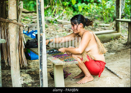 Amazonien, PERU - 10.November 2010: Unbekannter Amazoniens indigene Frau verkauft Souvenirs an die Touristen. Indigene Völker Amazoniens sind geschützt durch Stockfoto