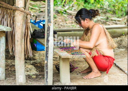 Amazonien, PERU - 10.November 2010: Unbekannter Amazoniens indigene Frau verkauft Souvenirs an die Touristen. Indigene Völker Amazoniens sind geschützt durch Stockfoto