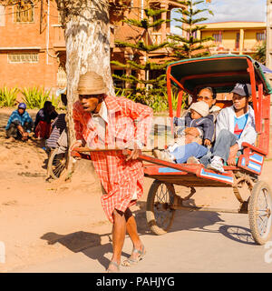 ANTANANARIVO, Madagaskar - 29. JUNI 2011: Unbekannter Madagaskar Mann trägt eine Beförderung Beförderung mit Mutter und Kinder. Menschen in Madagaskar Stockfoto