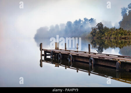 Anlegestelle am Lake Mapourika, West Coast, Neuseeland, an einem nebligen Morgen. Stockfoto