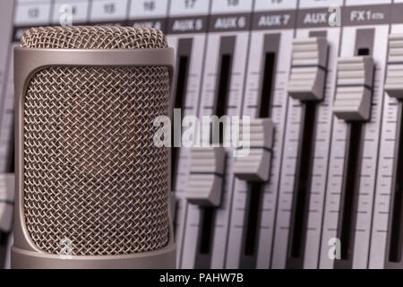 Professionelles Recording Mikrofon mit Studio Audio Mixer im Hintergrund. Vocal Lied Kontrollgerät in Nahaufnahme. Stockfoto