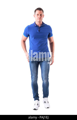 Cool Fit junger erwachsener Mann in Polo Shirt und Jeans Walking und Kamera. Voller Körper auf weißem Hintergrund. Stockfoto