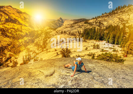 Wandern Frau Entspannung in Olmsted Point bei Sonnenuntergang Licht und auf der Nordseite Half Dome. Müde Wanderer ruht sich im Freien eine Pause vom Wandern. Yosemite Nationalpark, Kalifornien, USA Stockfoto