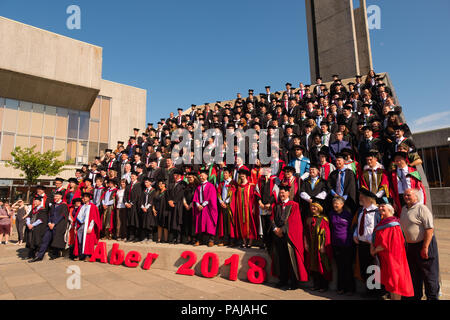 Hochschulbildung im Vereinigten Königreich: Absolventen von Aberystwyth University, in ihren traditionellen Mörser Boards und Schwarz akademische Kleider, für ihre traditionelle Gruppenfoto posiert. Juli 2018 Stockfoto