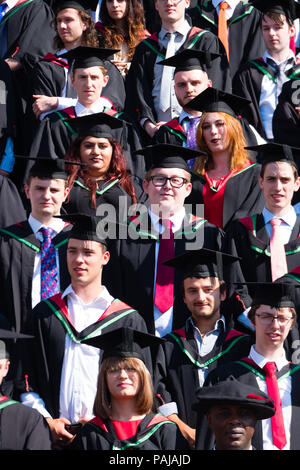 Hochschulbildung im Vereinigten Königreich: Absolventen von Aberystwyth University, in ihren traditionellen Mörser Boards und Schwarz akademische Kleider, für ihre traditionelle Gruppenfoto posiert. Juli 2018 Stockfoto