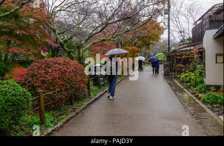 Kyoto, Japan - 19.November 2016. Menschen mit Sonnenschirmen zu Fuß auf Philosophen Weg an regnerischen Tag in Kyoto, Japan. Stockfoto