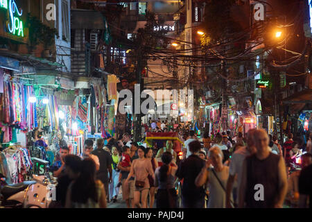 Night Shot eines der vielen geschäftigen Straßen, dass Hanoi's Night Market in der Altstadt, Vietnam umfassen. Der beliebte Markt findet am Wochenende in der e Stockfoto