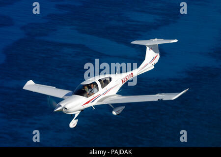 Eine Diamond DA40 Diamond Star Fliegen über dem Meer Stockfoto