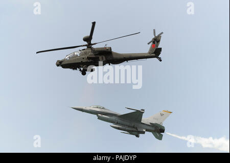 Singapur Luftwaffe RSAF Boeing AH-64 D Apache und Lockheed Martin F-16C Fighting Falcon mit weißen Rauch in der Flying-Display an der Singapore-Airsho Stockfoto