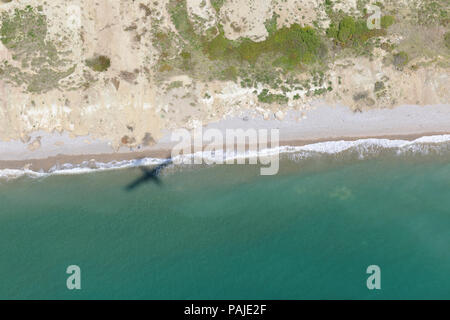 Schatten der Britten-Norman BN-2A fliegen über der Küste der Isle of Wight Stockfoto