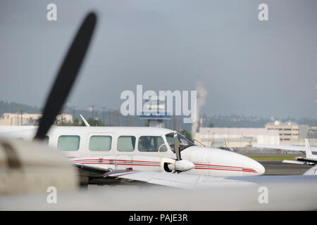 Windows der Aeroflight Executive Services Piper PA -31-350 Navajo Chieftain geparkt und Flugsicherung - Tower hinter Stockfoto