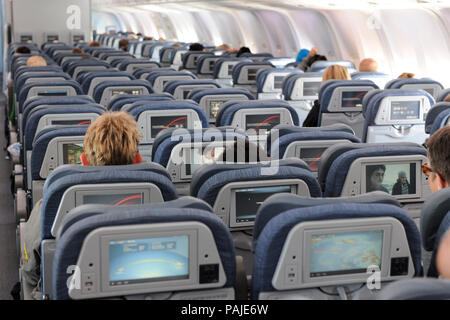 Passagiere in der Economy Class Sitzen - Sitzen eines Air Canada Boeing 767-300ER auf Flugnummer AC852 YYC-Linksseitiger Umkehrhebel Stockfoto