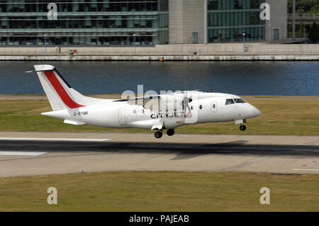 Scot Airways Dornier Do -328-100 Landung in London City mit Newham Docklands Gebäude hinter Stockfoto