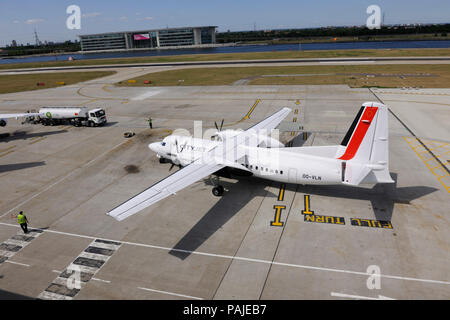 Flughelfer mit Fledermäusen Steuerung CityJet Fokker F-50 Rollen in London City mit Bowser hinter tanken Stockfoto