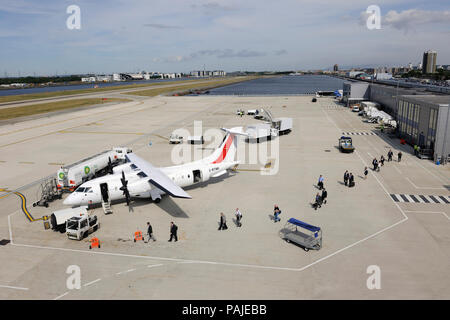 Passagiere mit tragen - auf Beuteln boarding ein Scot Airways Dornier Do -328-100, Traktor, Houchin Ground Power Unit, Air BP tanken Bowser, Gepäck trolles Stockfoto