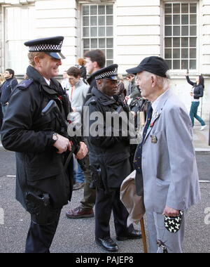 Polizei public relations. Bewaffnete Polizei sprechen Sie mit einem Mitglied der Öffentlichkeit in einem gut gelaunten Situation. Das Foto zeigt zwei bewaffneten uniformierten Polizisten und ein älterer Mann am Tag der Erinnerung November 2011. Stockfoto