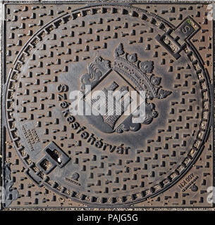 Ein Bügeleisen Kanaldeckel in einer Straße von Szekesfehervar, Ungarn Stockfoto