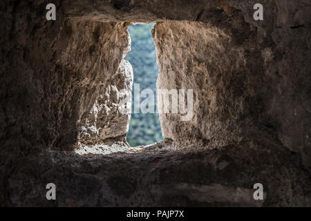 Berge in der Landschaft von einem Loch von einer antiken Mauer aus Stein von Sermoneta mittelalterliche Stadt in Italien. Stockfoto