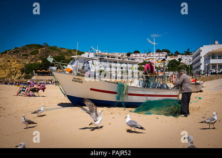 Kleinen Fischer ihre Netze Reinigung, in Salema an der Algarve, Portugal. Stockfoto