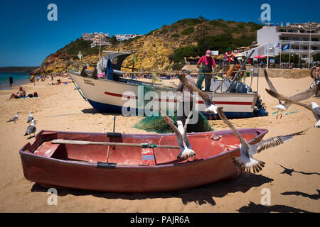 Kleinen Fischer ihre Netze Reinigung, in Salema an der Algarve, Portugal. Stockfoto