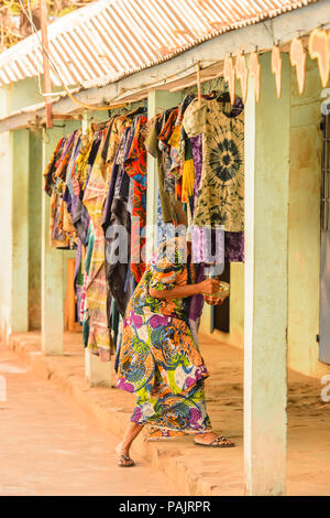 BANJUL, Gambia - Mar 14, 2013: Unbekannter gambischen Frau betritt den cothes Shop in Gambia, Mar 14, 2013. Große ethnische Gruppe in Gambia ist das mandinka Stockfoto